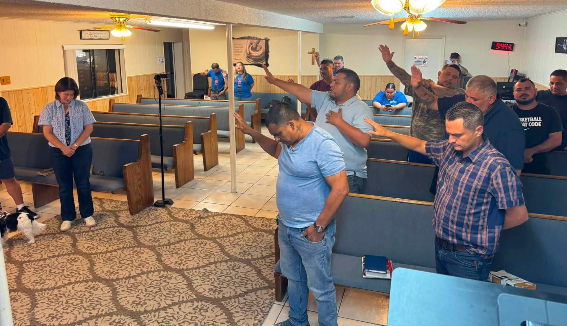 Men praying together with hands raised in worship